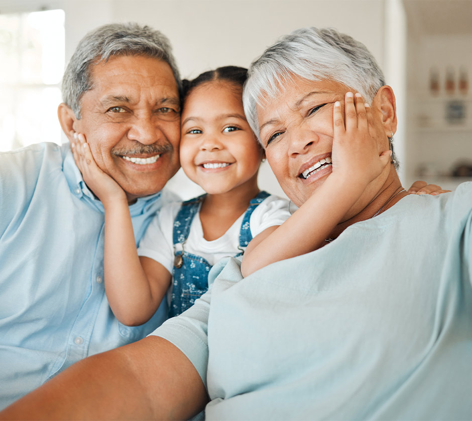 smiling grandparents with their granddaughter